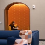 A student doing schoolwork in a yellow theme lounge on the second floor of Lowry Center at ɫƵ.
